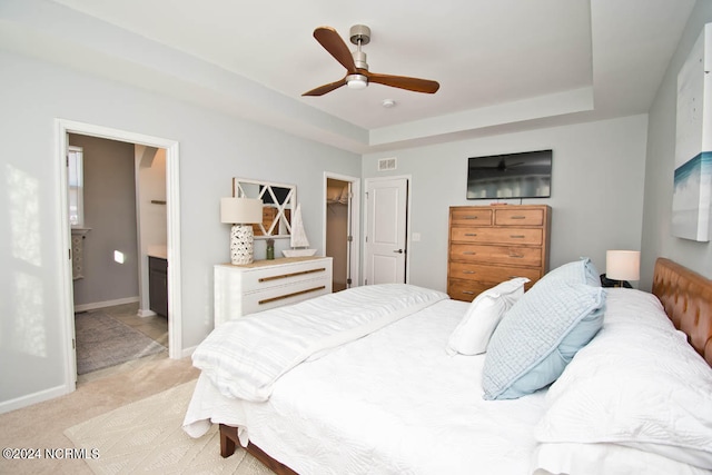 bedroom featuring a spacious closet, ensuite bath, a closet, light carpet, and ceiling fan