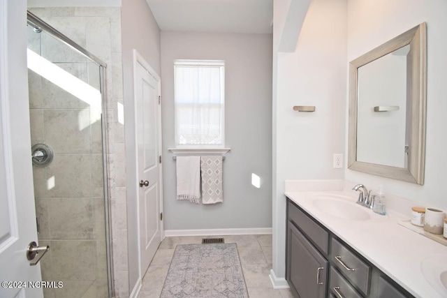 full bathroom featuring visible vents, double vanity, baseboards, a shower stall, and a sink