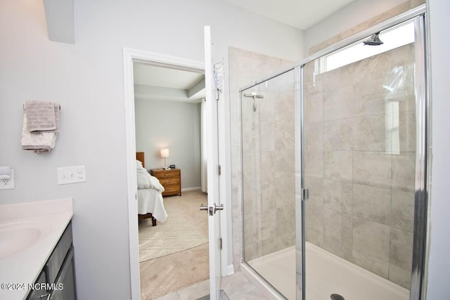 ensuite bathroom with ensuite bathroom, baseboards, vanity, and a shower stall