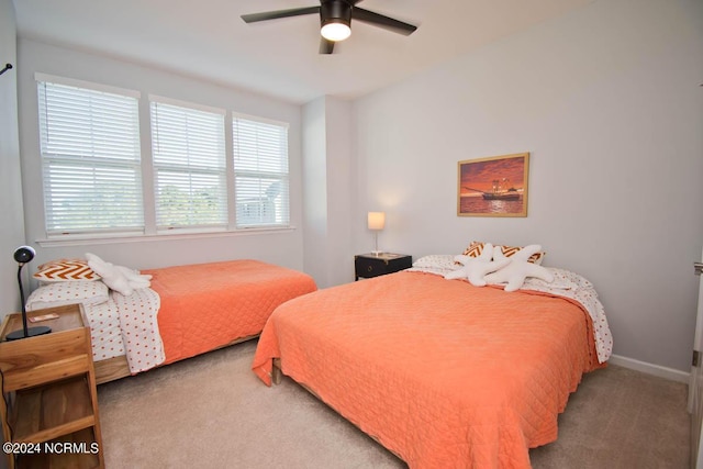 carpeted bedroom featuring baseboards and a ceiling fan