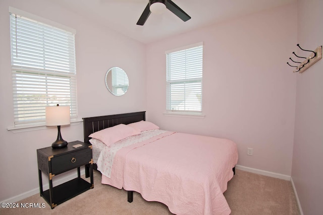 bedroom with light carpet, multiple windows, and ceiling fan