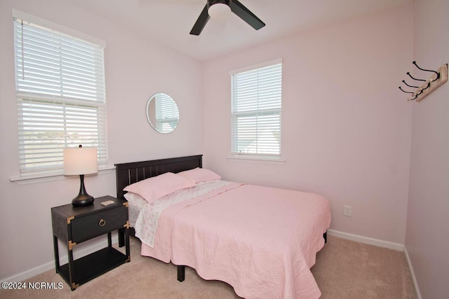 carpeted bedroom featuring baseboards and ceiling fan