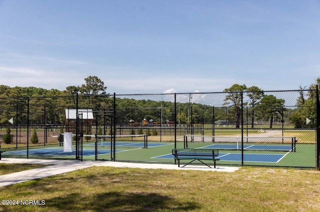 view of sport court with a lawn and fence