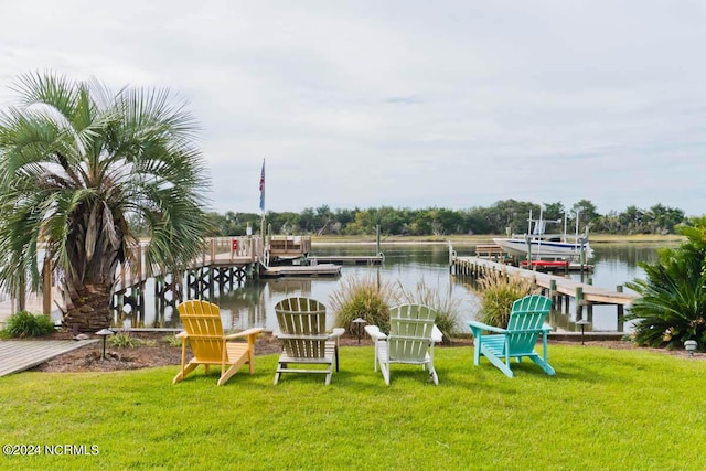dock area with a lawn, boat lift, and a water view
