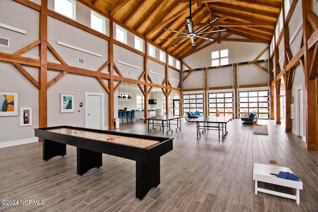 recreation room featuring hardwood / wood-style flooring, high vaulted ceiling, beamed ceiling, and ceiling fan