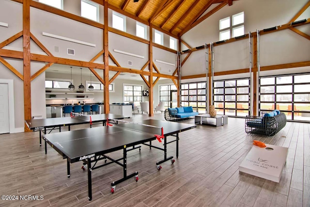 rec room with hardwood / wood-style flooring, high vaulted ceiling, beam ceiling, and wood ceiling