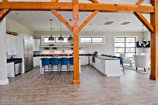 kitchen featuring a breakfast bar, white cabinets, dark countertops, and stainless steel appliances