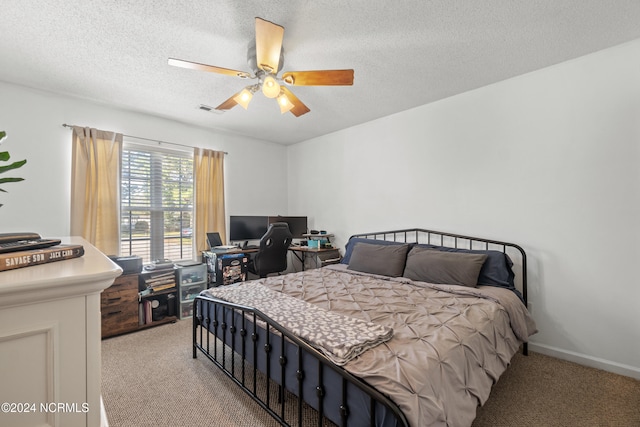 carpeted bedroom featuring ceiling fan and a textured ceiling