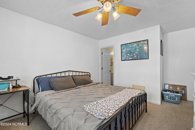 carpeted bedroom featuring ceiling fan and a textured ceiling