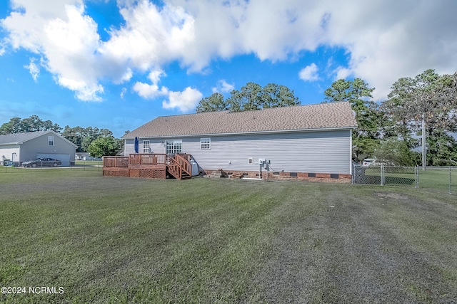 rear view of property with a yard and a wooden deck