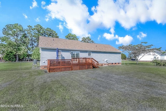 back of property featuring a lawn and a wooden deck