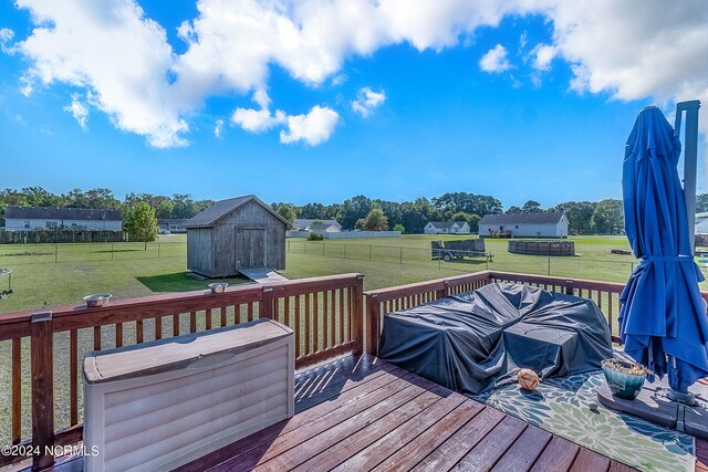 wooden terrace featuring a lawn and a storage unit