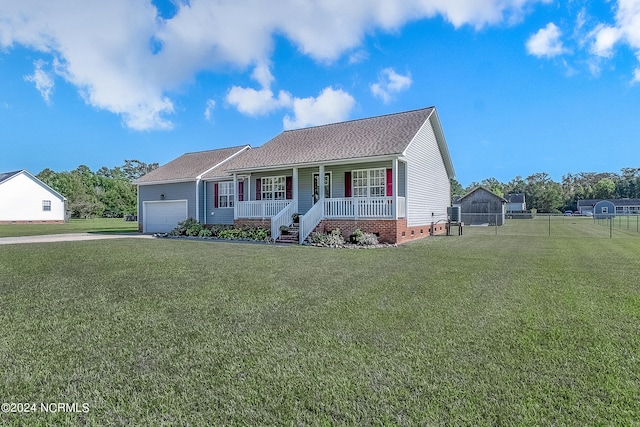 view of front of house featuring covered porch, a front yard, and a garage