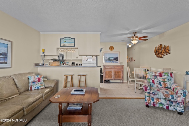 carpeted living room with ceiling fan and a textured ceiling