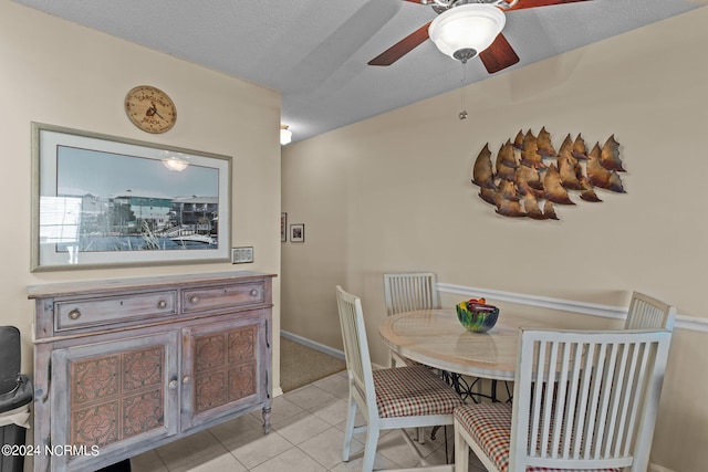 dining space featuring ceiling fan, light tile patterned floors, and a textured ceiling