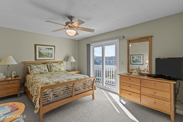 bedroom featuring access to outside, dark colored carpet, a textured ceiling, and ceiling fan