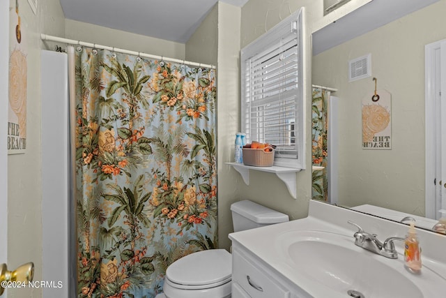 bathroom featuring vanity, toilet, and curtained shower