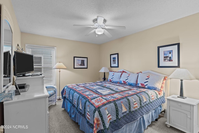 carpeted bedroom featuring a textured ceiling and ceiling fan