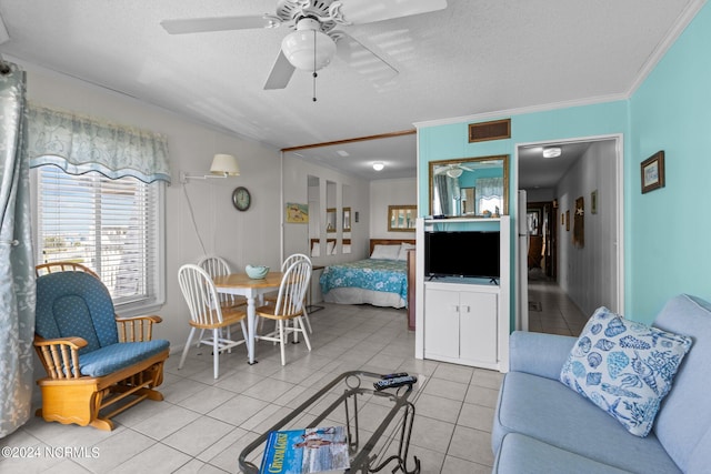 living room with a textured ceiling, crown molding, light tile patterned floors, and ceiling fan