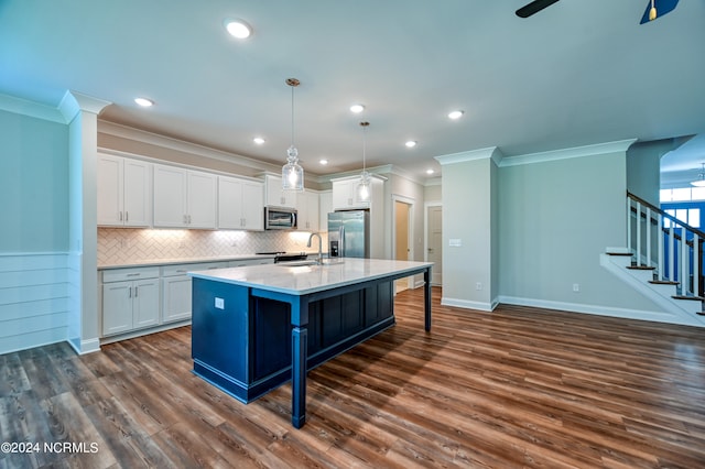 kitchen with white cabinets, a center island with sink, appliances with stainless steel finishes, and dark wood-type flooring