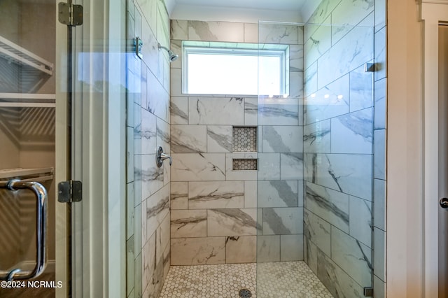 bathroom featuring a shower with shower door