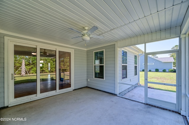 unfurnished sunroom with ceiling fan