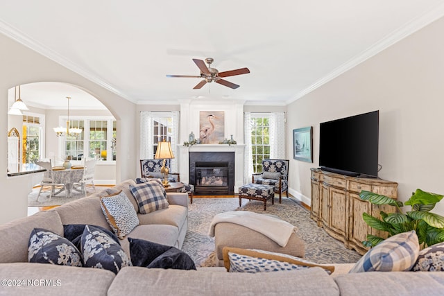 living room featuring ceiling fan with notable chandelier and ornamental molding