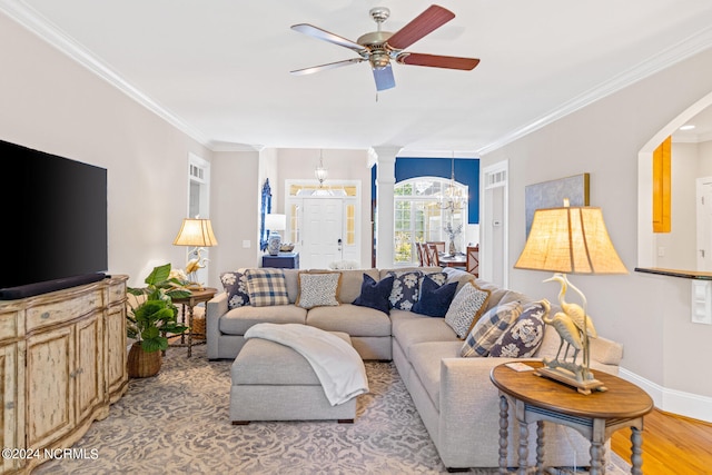 living room featuring ceiling fan with notable chandelier, light hardwood / wood-style flooring, and crown molding