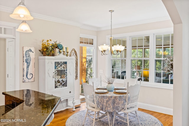 dining space with light wood-type flooring, a chandelier, and a healthy amount of sunlight