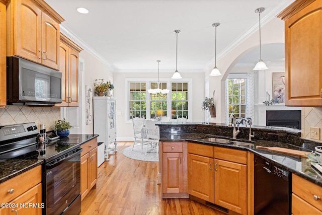 kitchen featuring decorative light fixtures, light wood-type flooring, sink, and black appliances