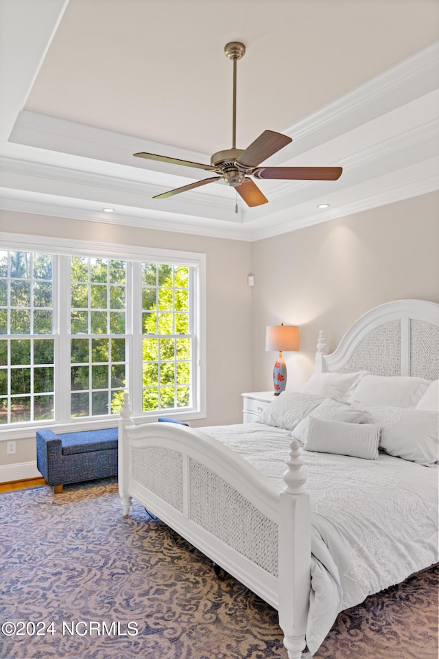 bedroom featuring ceiling fan, hardwood / wood-style flooring, a raised ceiling, and crown molding