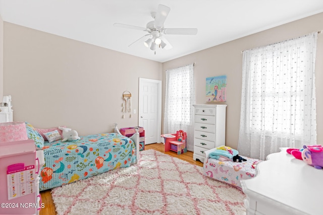 bedroom featuring hardwood / wood-style flooring, multiple windows, and ceiling fan