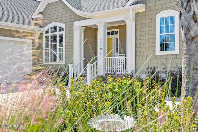 property entrance featuring a porch and a garage