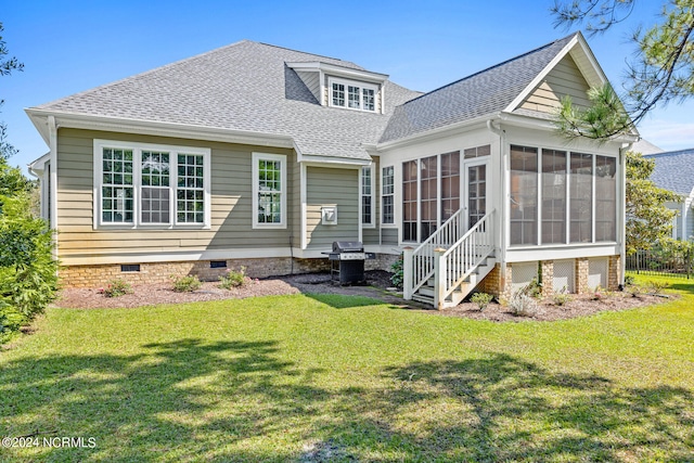 rear view of property featuring a sunroom and a lawn