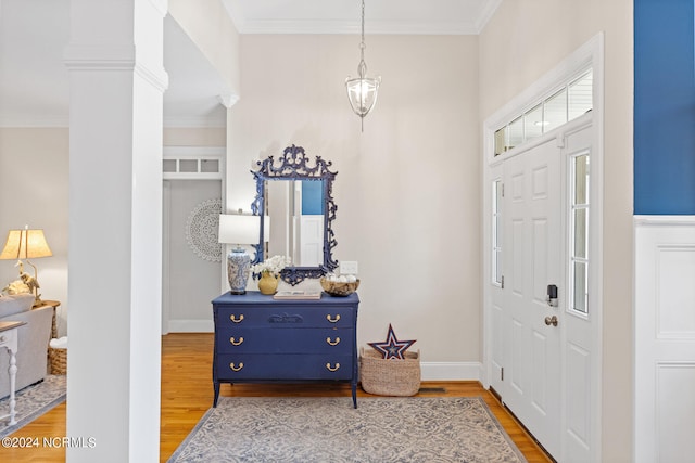 entryway featuring ornate columns, ornamental molding, and hardwood / wood-style floors