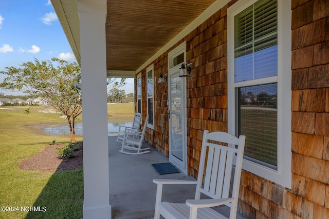 view of patio featuring covered porch and a water view