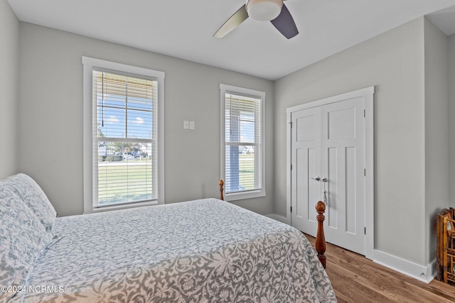 bedroom with wood-type flooring, multiple windows, and ceiling fan