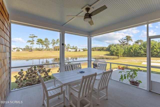 sunroom / solarium with ceiling fan, a water view, and plenty of natural light