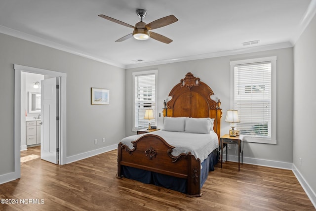 bedroom featuring ensuite bath, ornamental molding, ceiling fan, and dark wood-type flooring