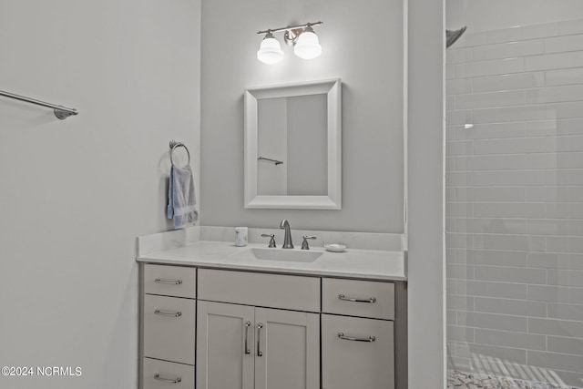 bathroom featuring a tile shower and vanity