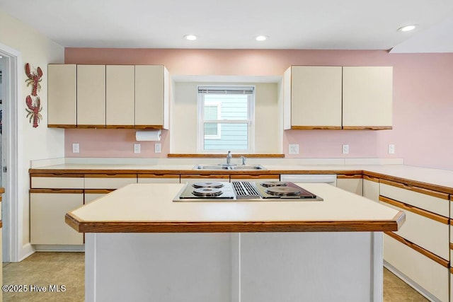 kitchen with cooktop, a kitchen island, and sink