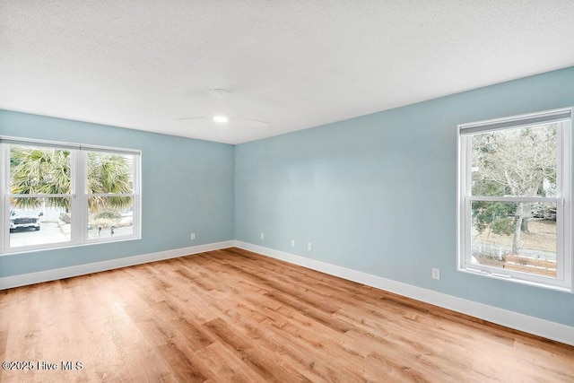 spare room with ceiling fan and light wood-type flooring