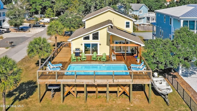 rear view of house with a pool side deck