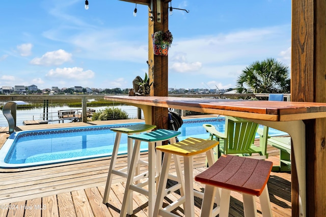 view of swimming pool with a water view and an outdoor bar