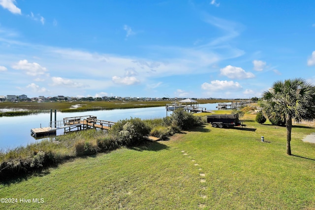 view of yard featuring a water view and a boat dock