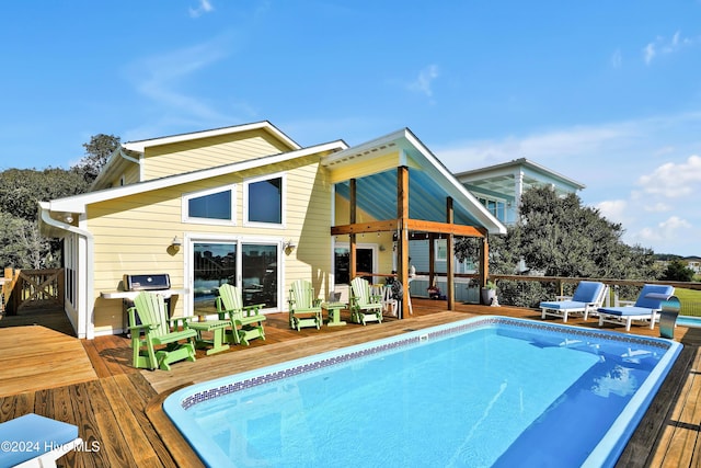 rear view of property featuring a pool side deck