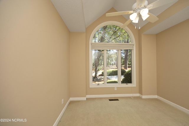 carpeted spare room featuring ceiling fan, a textured ceiling, and vaulted ceiling