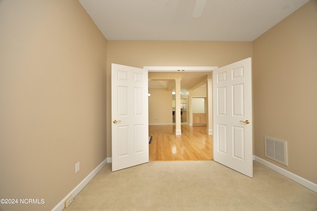 carpeted empty room featuring a textured ceiling