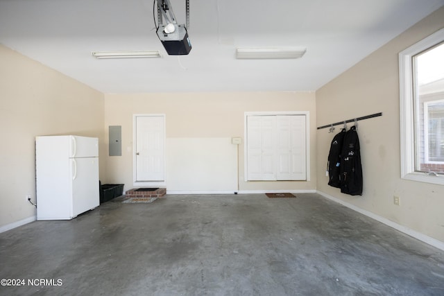 garage with a garage door opener, electric panel, and white fridge