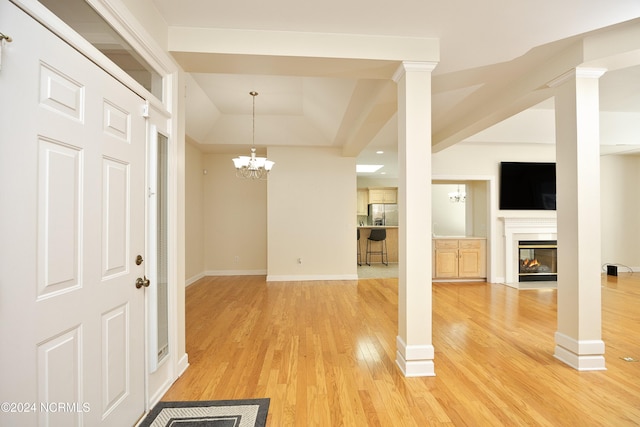 interior space with ornate columns, wood-type flooring, and a notable chandelier